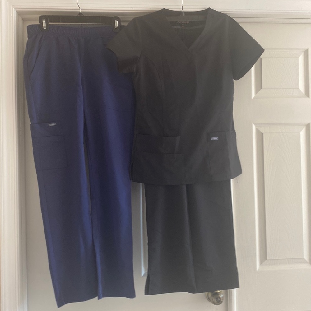 Two pair of Sanibel Scrubs, navy and black tops and pants.